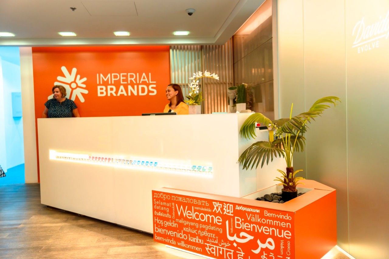Modern office reception desk with multilingual welcome signage.