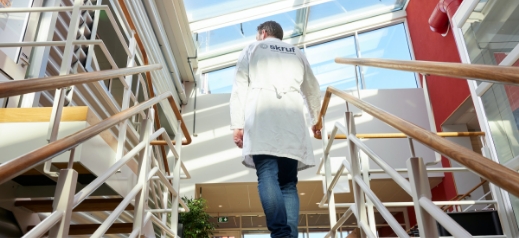 man in lab coat walking up the stairs